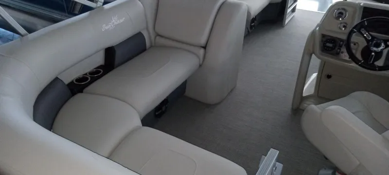 Slide: The Image of 2024 SunChaser Vista 20 CRB boat interior with beige seating and steering console. - 10