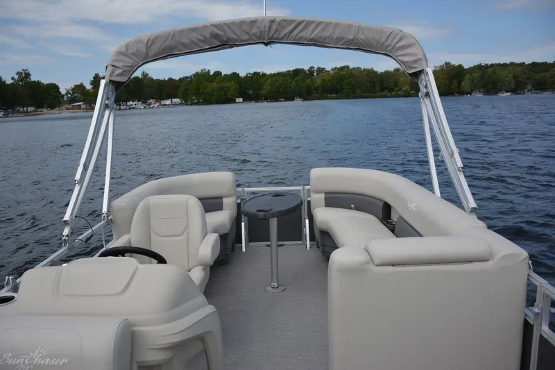 Slide: The Image of 2024 SunChaser Vista 20 CRB pontoon boat on a lake with comfortable seating. - 14