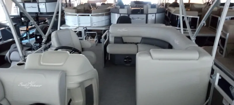 Slide: The Image of 2024 SunChaser Vista 20 CRB pontoon boat interior with beige seating and steering console. - 7