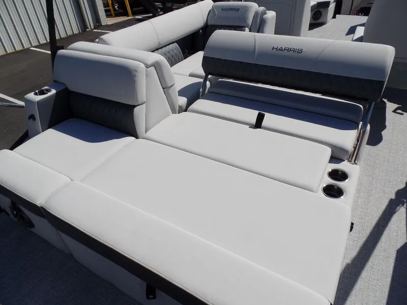 Slide: The Image of 2024 Harris Sunliner 230 boat with luxurious white seating and cup holders. - 14
