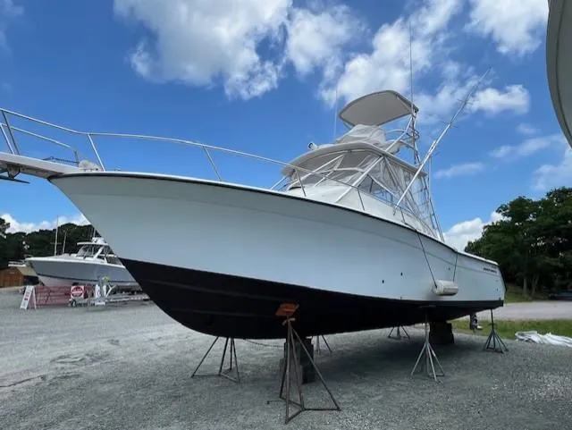 Slide: The Image of 2002 Grady-White 330 Express boat on stands under a blue sky. - 31
