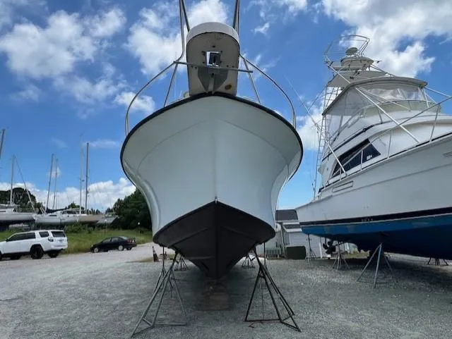 Slide: The Image of 2002 Grady-White 330 Express boat on dry dock under a blue sky. - 32