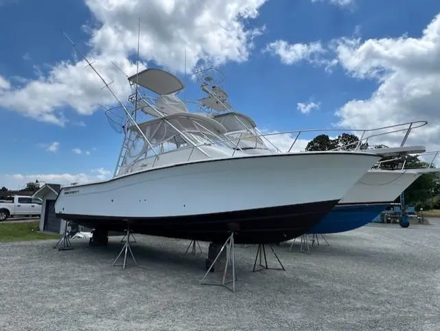 Slide: The Image of 2002 Grady-White 330 Express boat on stands under a partly cloudy sky. - 33