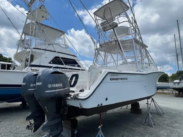 Slide: The Image of 2002 Grady-White 330 Express boat with twin Yamaha engines, docked outdoors. - 34