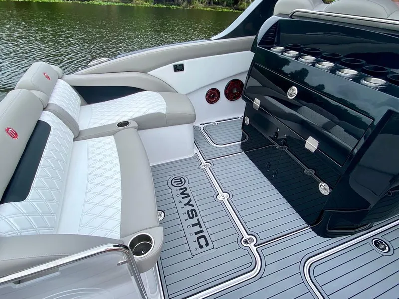 Slide: The Image of 2020 Mystic Powerboats M4200 interior with luxurious seating and sleek design on a serene water backdrop. - 11