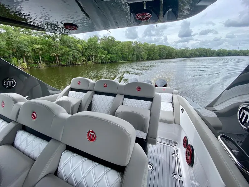 Slide: The Image of 2020 Mystic Powerboats M4200 interior with luxurious seating on a scenic river. - 22