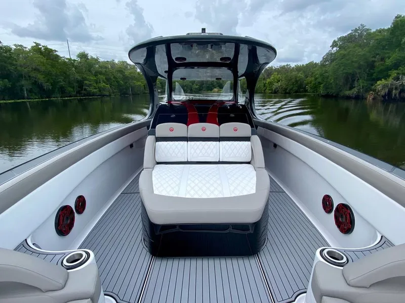 Slide: The Image of 2020 Mystic Powerboats M4200 on a serene river, featuring luxurious seating and sleek design. - 24