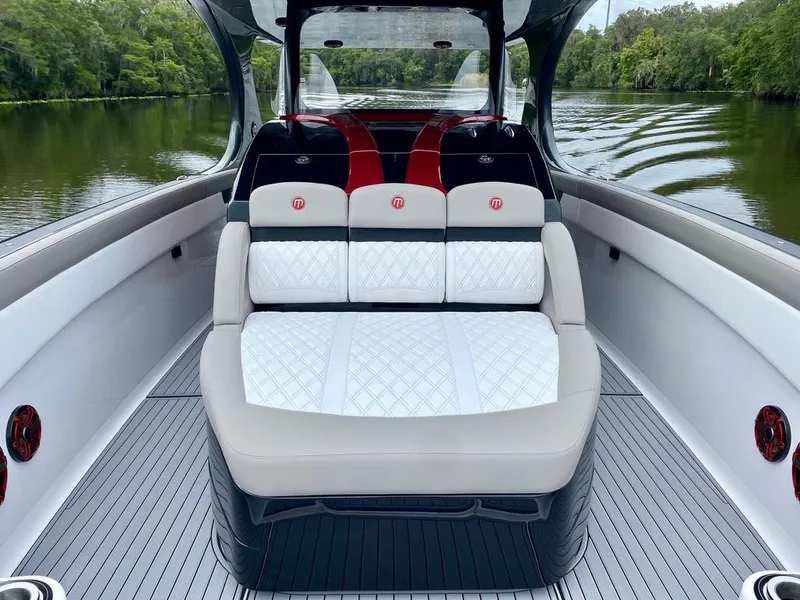 Slide: The Image of 2020 Mystic Powerboats M4200 interior with luxurious seating on a serene waterway. - 26