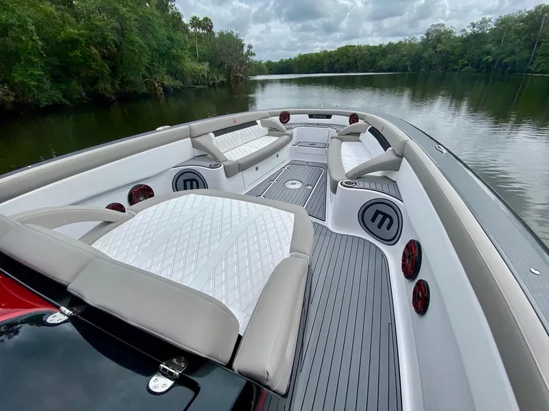Slide: The Image of 2020 Mystic Powerboats M4200 interior with luxurious seating on a serene river. - 29