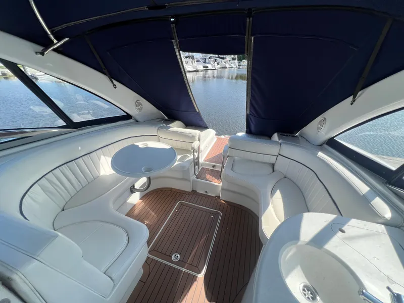 Slide: The Image of Interior of a 2003 Cobalt 360 boat with white seating and wooden flooring. - 13