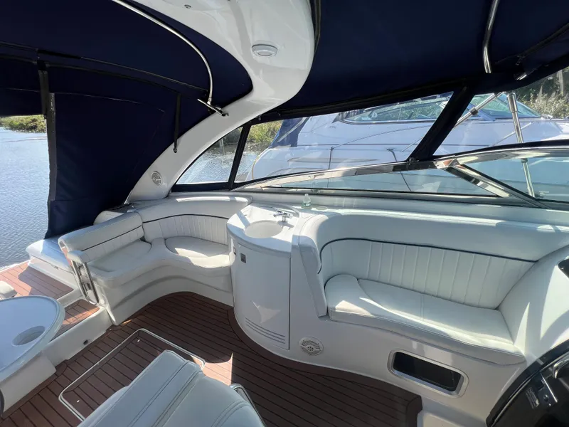 Slide: The Image of Interior of a 2003 Cobalt 360 boat with white seating and blue canopy. - 14