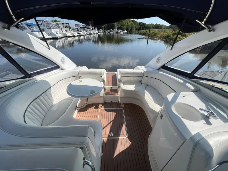 Slide: The Image of Luxurious 2003 Cobalt 360 boat interior with white seating and wooden deck, docked by a serene marina. - 15