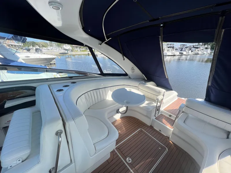 Slide: The Image of 2003 Cobalt 360 boat interior with white seating and wooden flooring. - 17