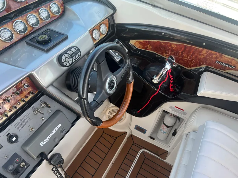 Slide: The Image of Cockpit of a 2003 Cobalt 360 boat with steering wheel and control panel. - 20