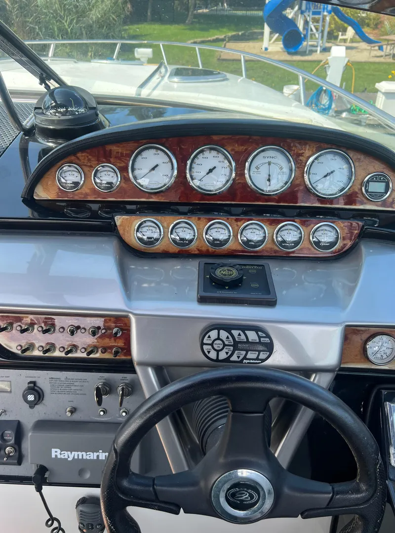 Slide: The Image of 2003 Cobalt 360 boat dashboard with gauges and steering wheel. - 23