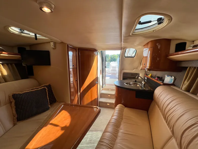 Slide: The Image of Interior of 2003 Cobalt 360 yacht with leather seating, kitchenette, and TV. - 32