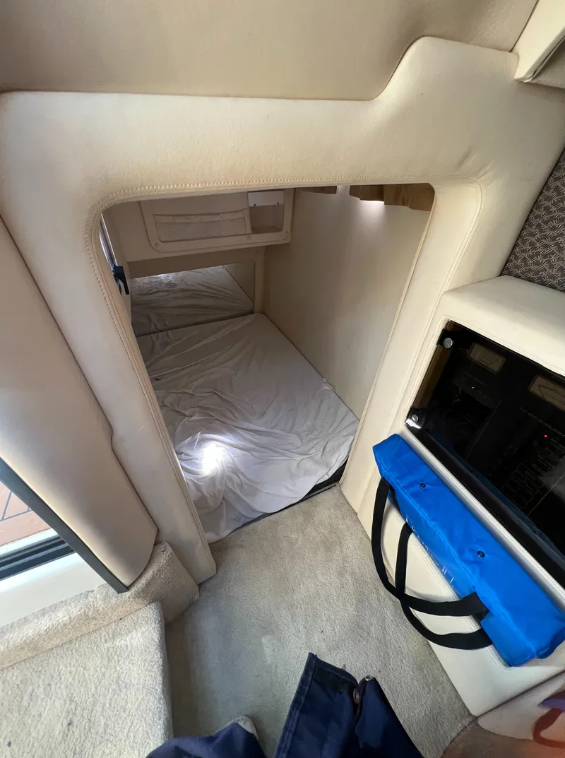 Slide: The Image of Interior cabin of a 2003 Cobalt 360 boat with a small bed and storage. - 33