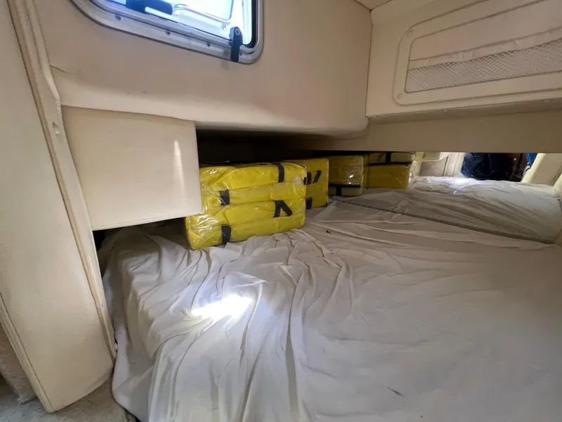 Slide: The Image of Interior of a 2003 Cobalt 360 boat with yellow packages on a bed. - 35
