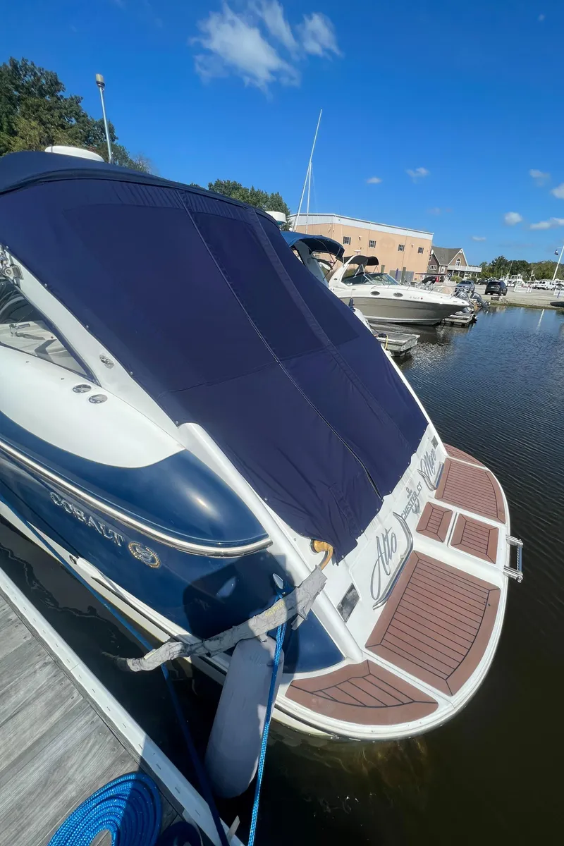 Slide: The Image of 2003 Cobalt 360 boat docked at a marina with a blue cover. - 5