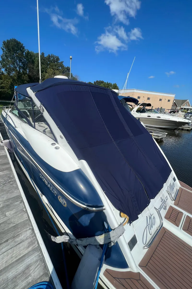 Slide: The Image of 2003 Cobalt 360 boat docked at marina with blue cover. - 6