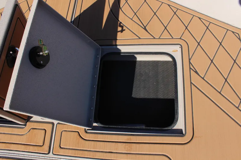 Slide: The Image of Open storage compartment on 2024 Avid ROGUE boat with wood-patterned deck. - 21