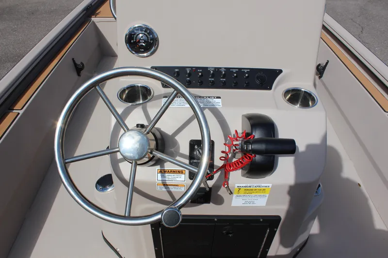 Slide: The Image of 2024 Avid ROGUE boat steering console with wheel, controls, and warning labels. - 15