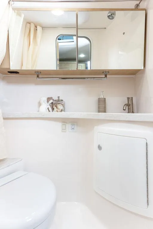 Slide: The Image of 2024 Regal 28 Express boat bathroom with mirror, sink, and storage. - 11