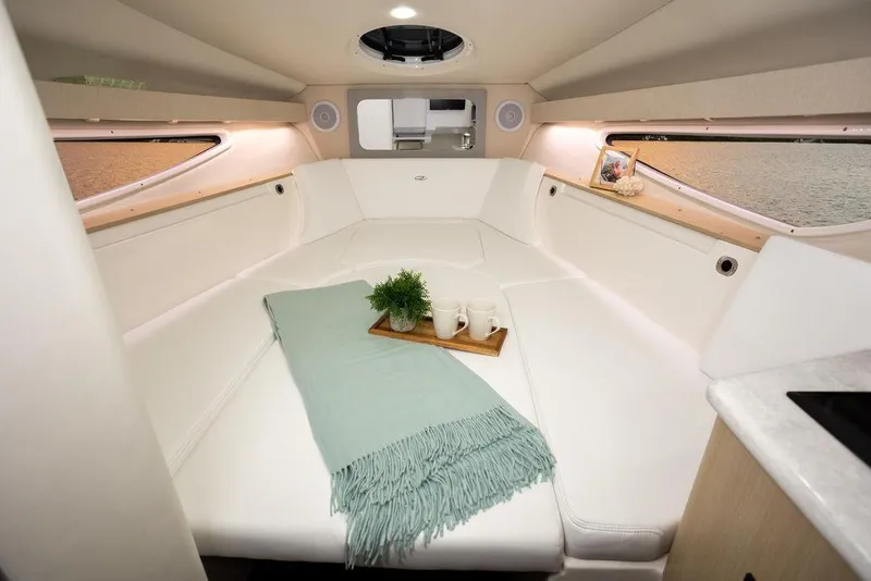 Slide: The Image of 2024 Regal 28 Express cabin interior with white seating and cozy decor. - 12
