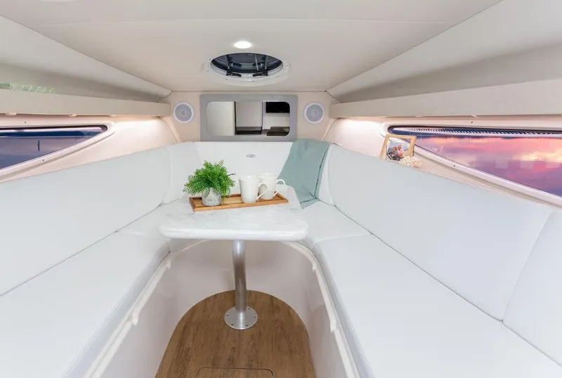 Slide: The Image of 2024 Regal 28 Express cabin interior with white seating and table. - 16