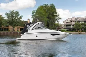 Slide: The Image of 2024 Regal 28 Express boat on a calm lake with houses in the background. - 23