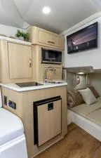 Slide: The Image of 2024 Regal 28 Express boat interior with kitchenette and cozy seating area. - 27