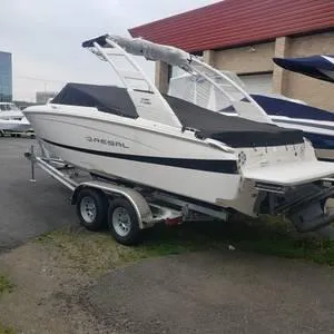 Slide: The Image of 2024 Regal 28 Express boat on a trailer, parked near a building. - 33