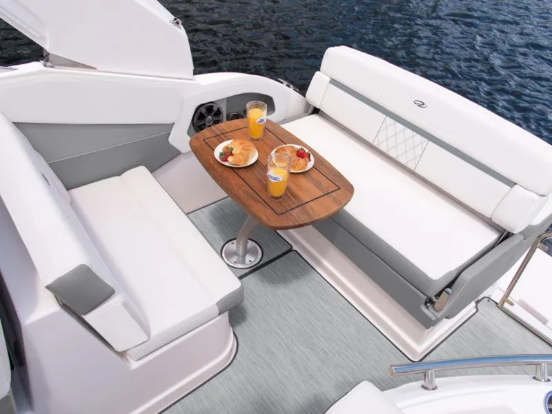Slide: The Image of 2024 Regal 28 Express boat interior with dining setup and lake view. - 7