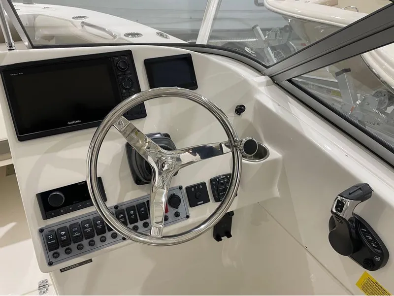 Slide: The Image of 2024 Key West 239 DFS boat dashboard with Garmin display and steering wheel. - 13
