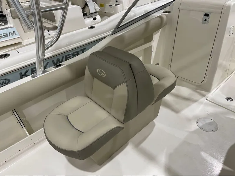 Slide: The Image of 2024 Key West 239 DFS boat interior with beige seating and stainless steel fixtures. - 23