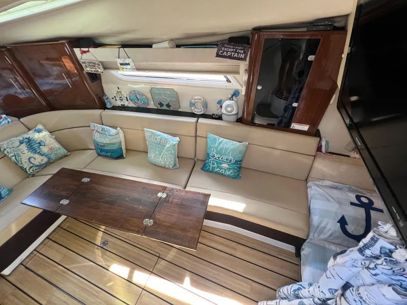 Slide: The Image of Interior of 2014 Regal 35 Sport Coupe with beige seating, wooden table, and nautical decor. - 10