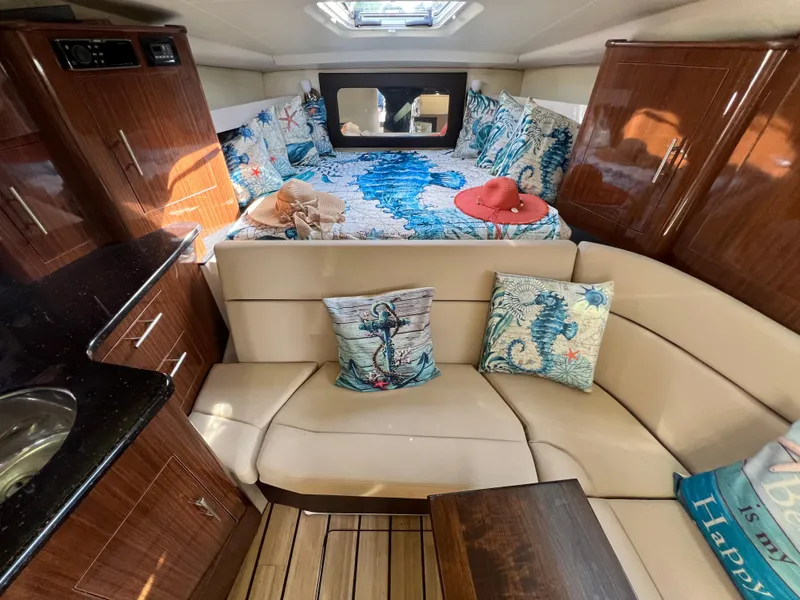 Slide: The Image of 2014 Regal 35 Sport Coupe interior with cozy seating and nautical-themed decor. - 13