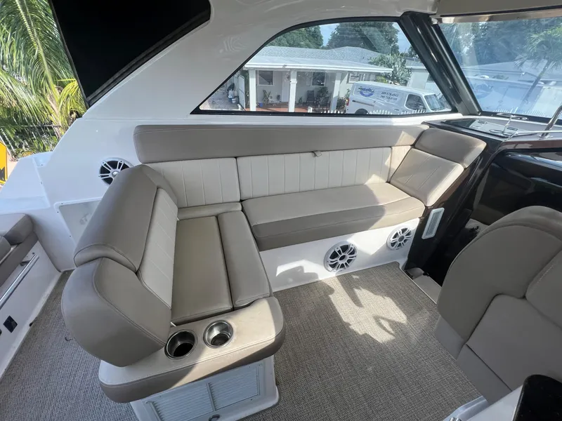 Slide: The Image of Interior seating area of a 2014 Regal 35 Sport Coupe boat with beige upholstery. - 19