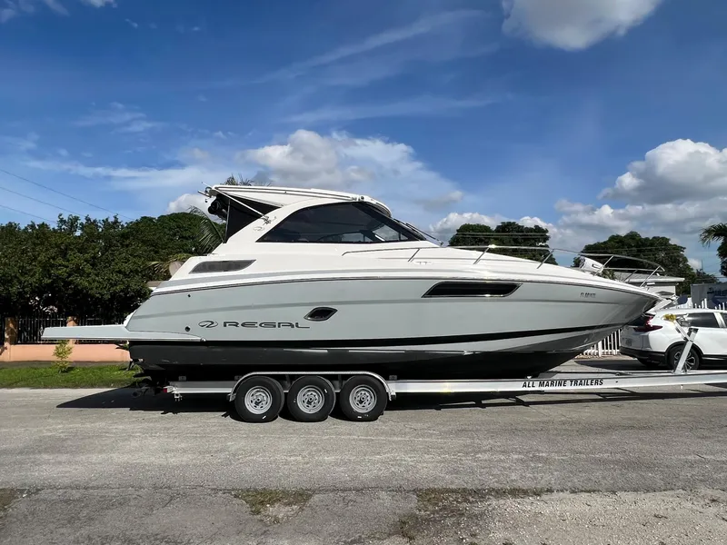 Slide: The Image of 2014 Regal 35 Sport Coupe boat on a trailer under a blue sky. - 2