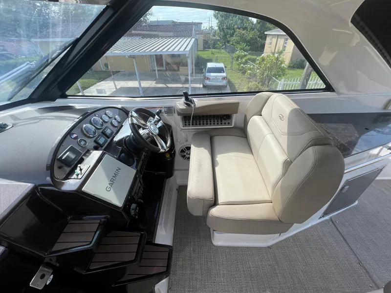 Slide: The Image of Helm station of a 2014 Regal 35 Sport Coupe with beige seating and Garmin navigation. - 20
