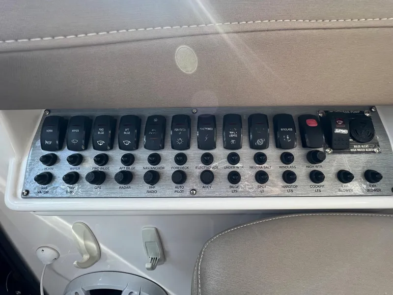 Slide: The Image of Control panel of a 2014 Regal 35 Sport Coupe boat with various switches and buttons. - 34