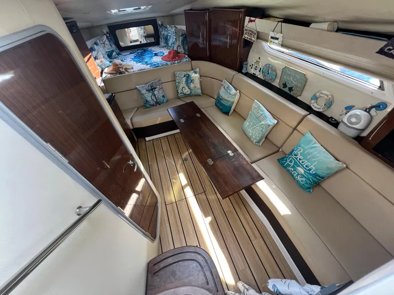 Slide: The Image of Interior of 2014 Regal 35 Sport Coupe with beige seating, wooden table, and nautical decor. - 9