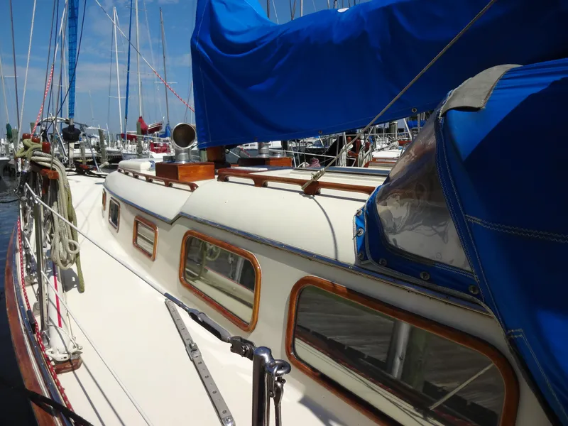 The Image of 1966 Cheoy Lee 36 Offshore Flying Buffalo sailboat docked, featuring blue covers and wooden accents. - 0