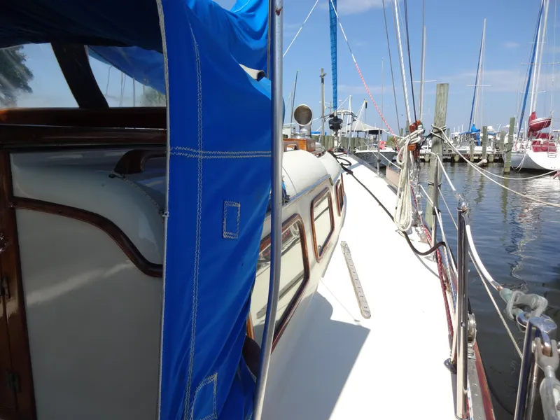 Slide: The Image of 1966 Cheoy Lee 36 Offshore Flying Buffalo sailboat docked at marina, blue canopy visible. - 11