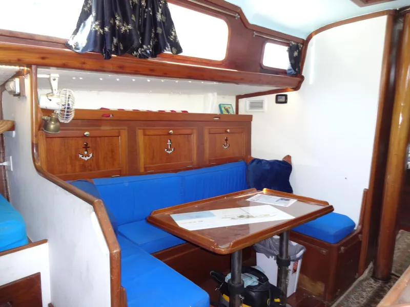 Slide: The Image of Interior of 1966 Cheoy Lee 36 Offshore Flying Buffalo with blue seating and wooden cabinetry. - 22