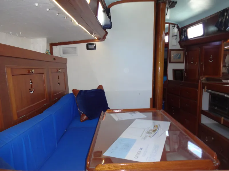Slide: The Image of Interior of 1966 Cheoy Lee 36 Offshore Flying Buffalo, featuring wooden cabinetry and blue seating. - 24