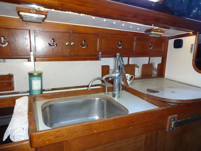 Slide: The Image of 1966 Cheoy Lee 36 Offshore Flying Buffalo yacht kitchen with wooden cabinets and stainless steel sink. - 27