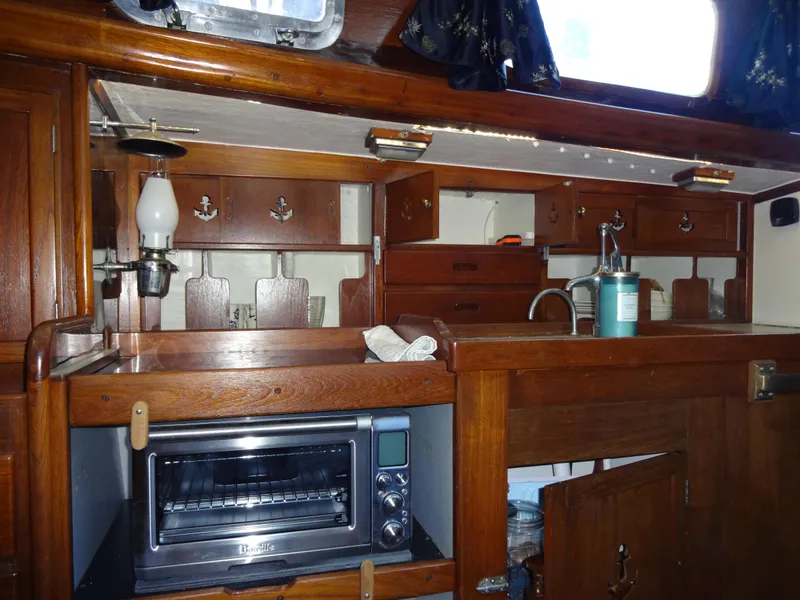Slide: The Image of 1966 Cheoy Lee 36 Offshore Flying Buffalo yacht interior with wooden cabinetry and kitchen amenities. - 28