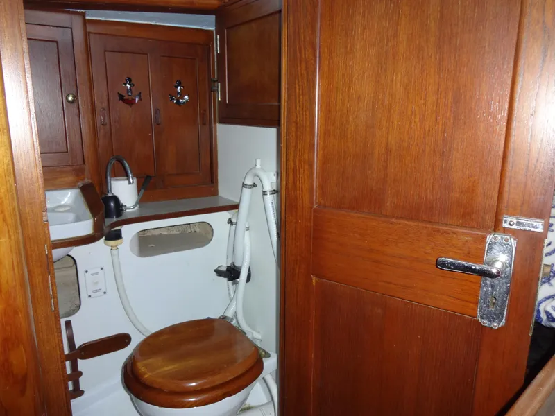 Slide: The Image of 1966 Cheoy Lee 36 Offshore Flying Buffalo yacht bathroom with wooden cabinetry and marine toilet. - 33