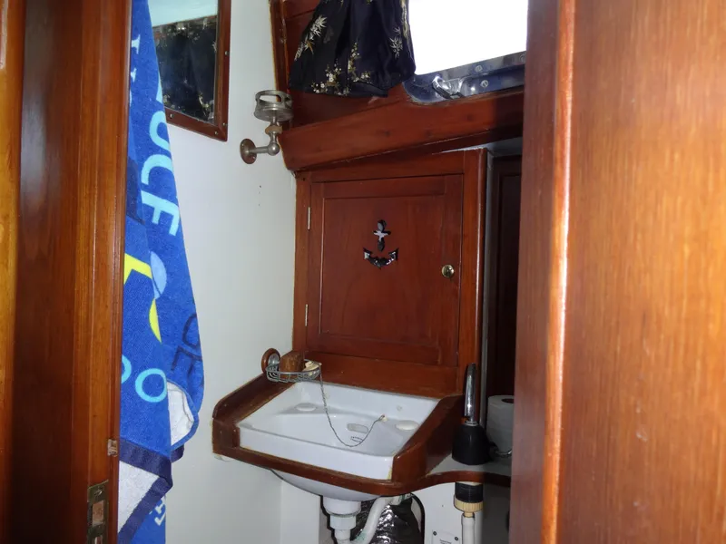 Slide: The Image of 1966 Cheoy Lee 36 Offshore Flying Buffalo yacht bathroom with wooden cabinetry and sink. - 34